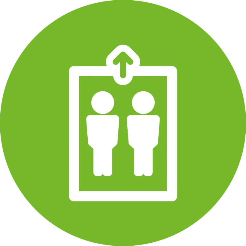 Weißes Piktogramm eines Aufzugs mit zwei stehenden Personen und Aufwärtspfeil, dargestellt vor grünem Kreis – Symbol für Aufzug oder barrierefreien Zugang.